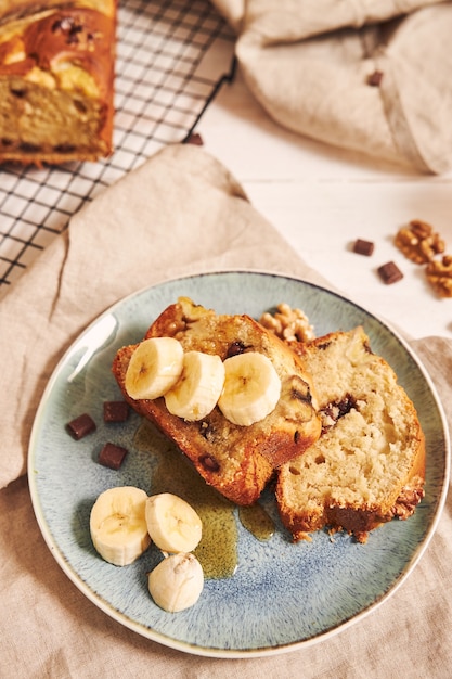 Vertical shot of slices of delicious banana bread with chocolate chunks and walnut on a plate