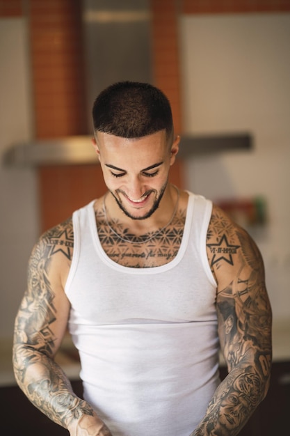 Vertical shot of a smiling Caucasian tattooed male athlete