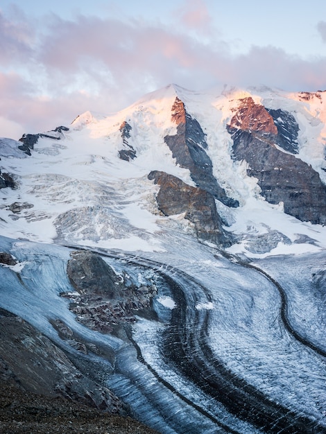 Vertical shot of a snowy mountain under a cloudy sky