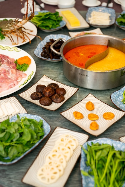 Vertical shot of a soup and side dishes with leaf vegetable and spices