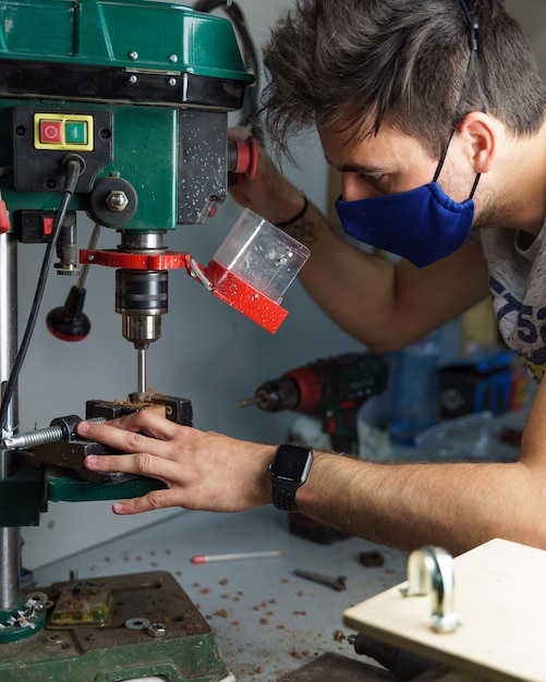 Vertical shot of a Spanish Caucasian man wearing a facemask, working in the warehouse