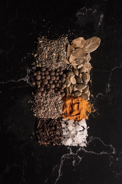 Free photo vertical shot of spices and seeds on black background