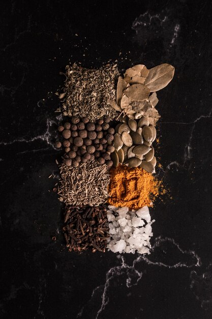 Vertical shot of spices and seeds on black background