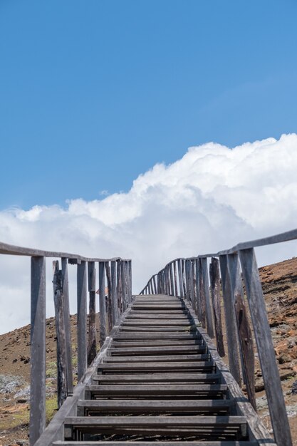 エクアドルのガラパゴス諸島の空に触れる山々に通じる階段の垂直ショット