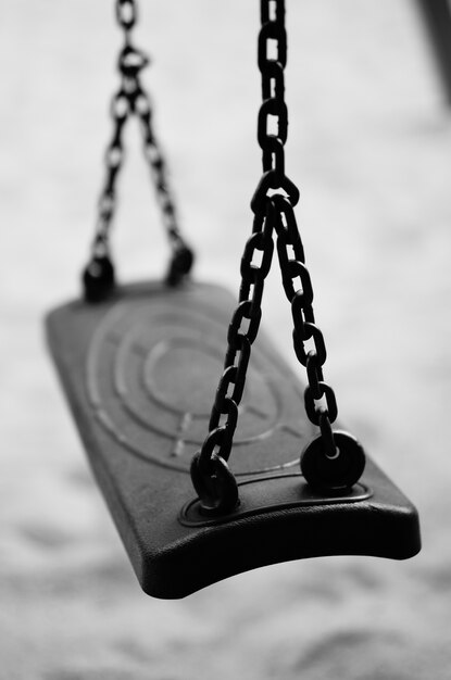 Vertical shot of a swing attached to metal chains