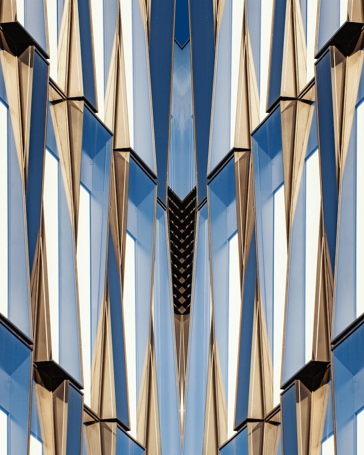 Free Photo vertical shot of a symmetrical blue glass and concrete building
