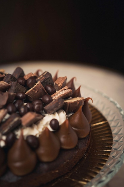 Vertical shot of a tasty chocolate cake on a glass plate on a table