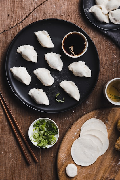 Free photo vertical shot of traditional chinese dumplings with chopsticks on a wooden table