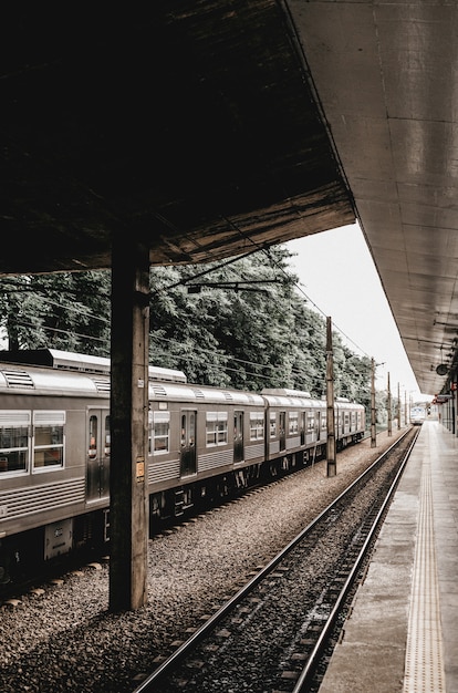 Vertical shot of a train stop with a grey metallic train leaving