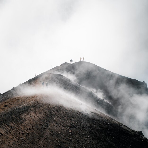 霧の山の頂上での旅行者の垂直ショット