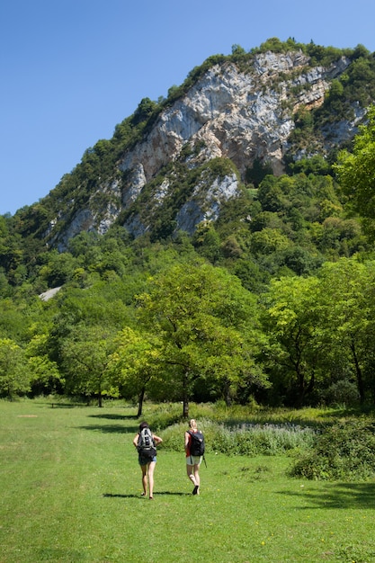 Вертикальный снимок двух женщин-путешественниц, путешествующих по зеленой природе Сердон, Айн, на востоке Франции