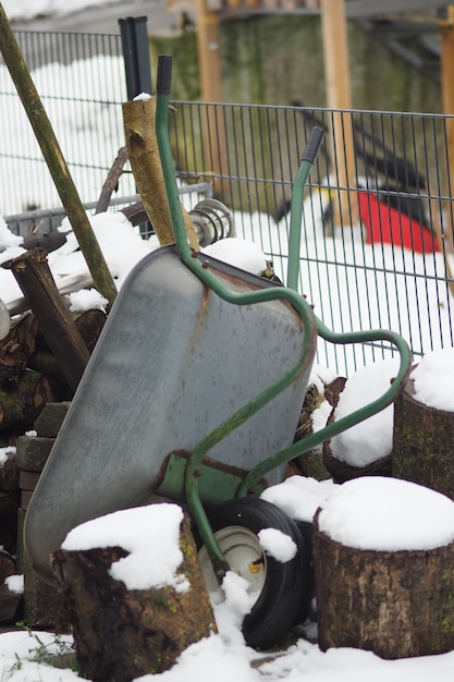 Free photo vertical shot of an upside-down wheelbarrow during winter