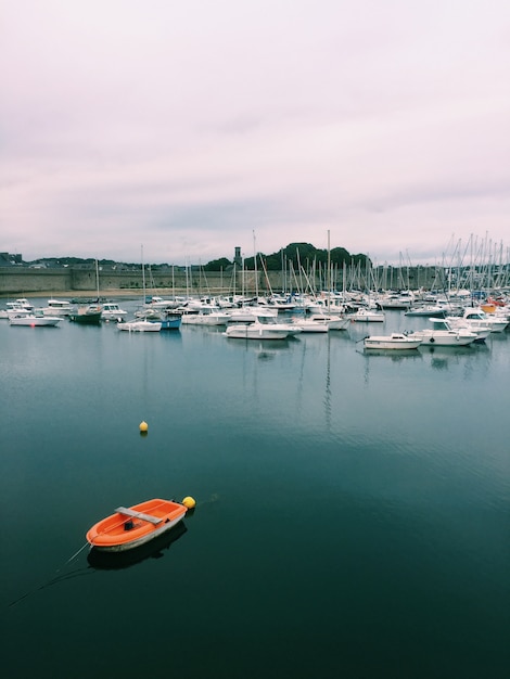 Free photo vertical shot of various boats on the body of water under a cloudy sky