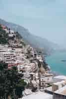 Foto gratuita colpo verticale della vista del villaggio di positano in italia vicino al mare durante la luce del giorno