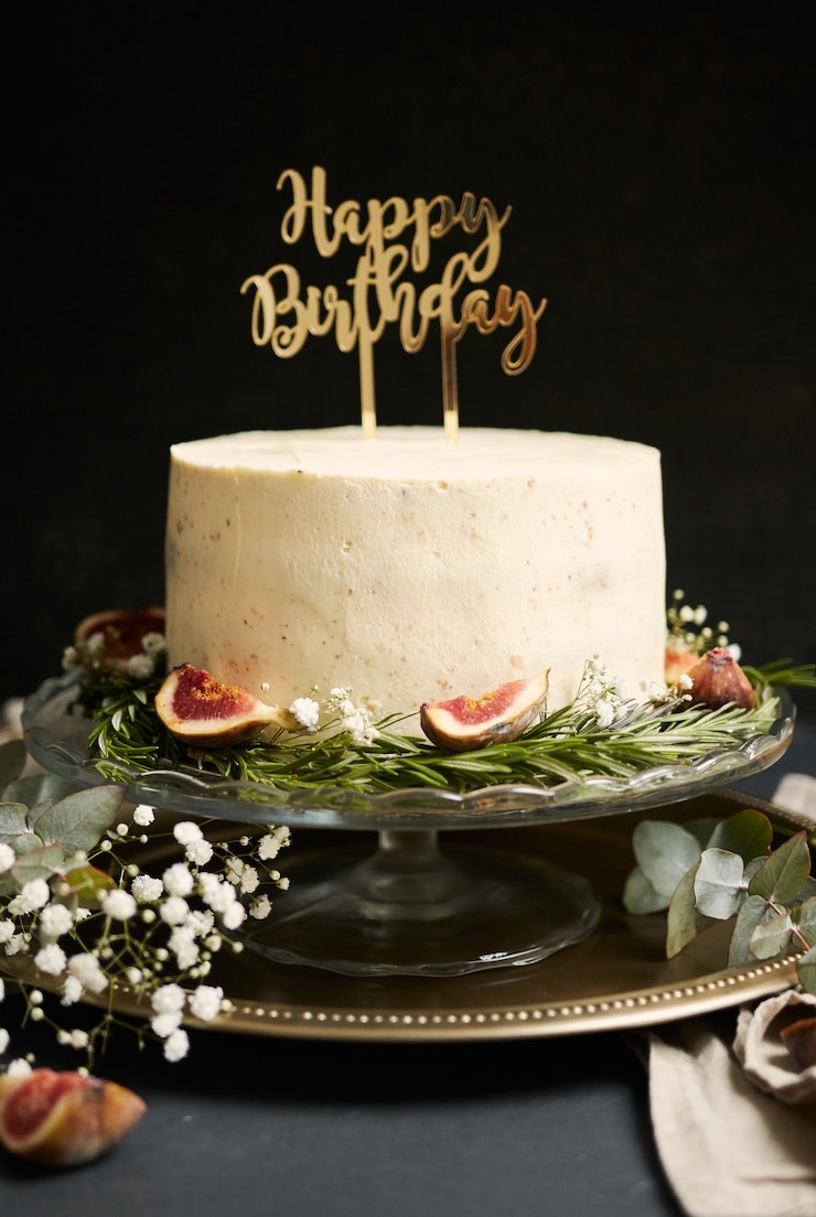 Free Photo vertical shot of a white happy birthday dream cake with green leaves at the bottom