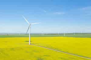 Free photo vertical shot of wind generators in a large field during daytime