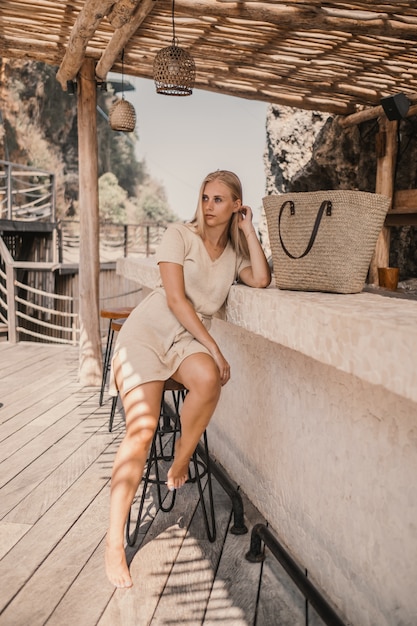 Vertical shot of a woman sitting next to the bar stand during daytime