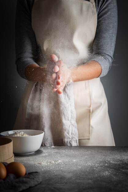 Vertical shot woman with flour in palms