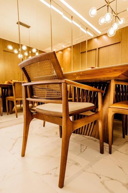 Vertical shot of wooden chairs and tables in a modern living room