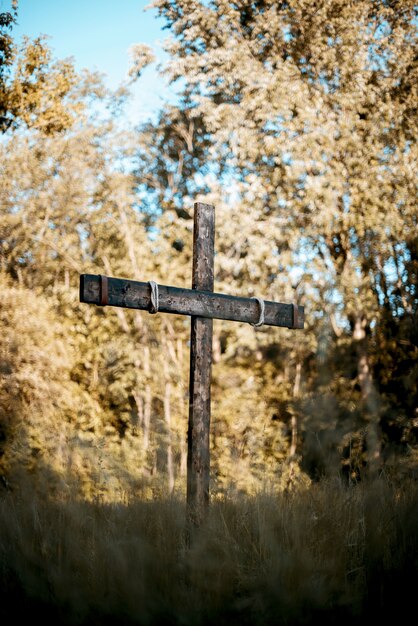 Vertical shot of a wooden cross on a grassy field