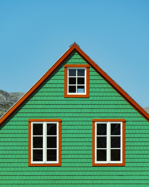 Free photo vertical shot of a wooden green house under the clear blue sky