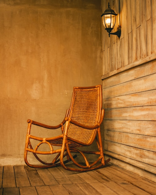 Foto gratuita ripresa verticale di una sedia a dondolo in legno su un patio in legno