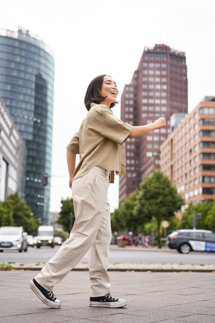 無料Photo 幸せなポーズをとって手を上げて勝利を祝う若いアジア女性の垂直ショット