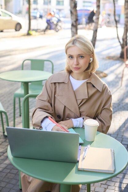 vertical-shot-young-blond-woman-wireless-headphones-making-notes-studying-online-attend-web_1258-205435.jpg
