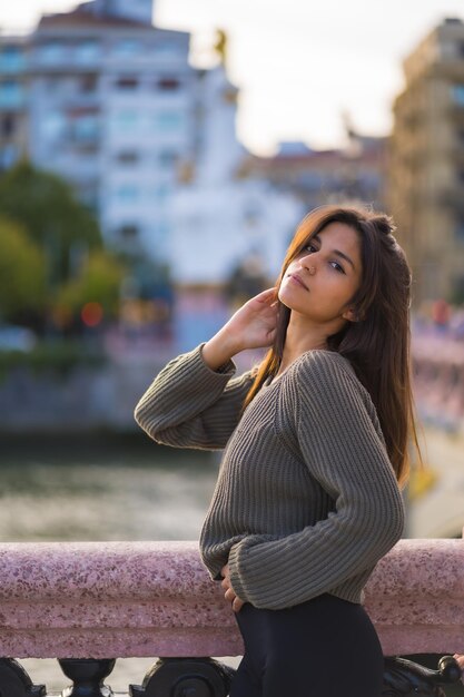 都市でポーズをとっている若い白人女性の垂直ショット