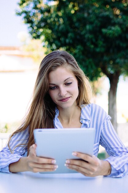 Vertical shot of a young female in a striped white and blue shirt working from home