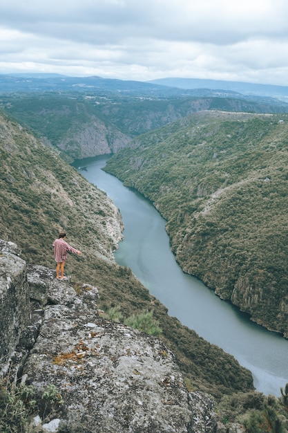 Vertical shot of a young woman in Sil Canyon in Spain