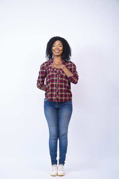 Vertical shot of a young woman standing with one hand on her chest in support of a cause