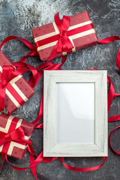 Vertical view of beautifully packaged gift boxes tied with ribbon picture frame on icy