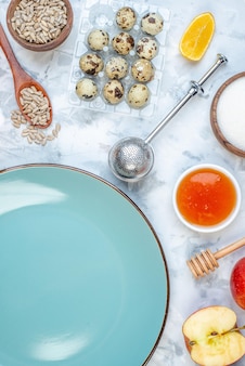 Vista verticale del piatto vuoto blu e degli ingredienti per i cibi sani sul tavolo del ghiaccio