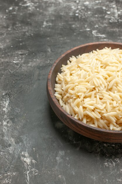 Vertical view of boiled rice in a brown wooden pot