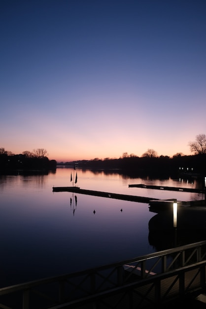 Foto gratuita vista verticale di un fiume calmo sotto il bel cielo limpido al tramonto