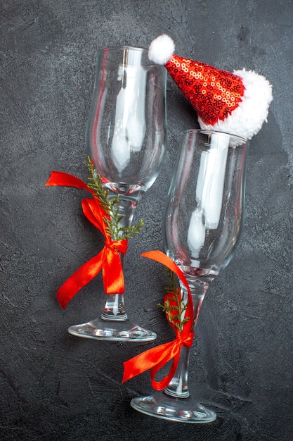 赤と黒の表面にクリスマスサンタクロース帽子ガラスゴブレットの垂直方向のビュー