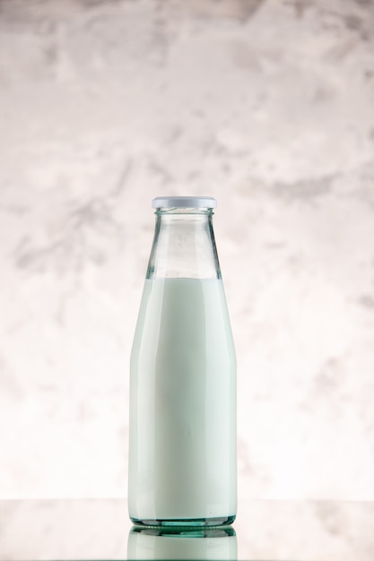 Вертикальный вид закрытой и наполненной молоком стеклянной бутылки на фоне белого дыма со свободным пространством