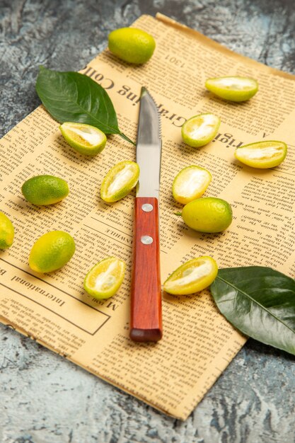 Vertical view of cut in half fresh kumquats on newspapers on gray background footage