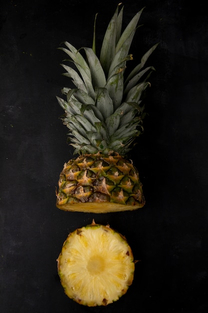 Vertical view of cut pineapple on black surface