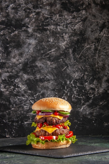 Вертикальный вид вкусного мясного сэндвича с зелеными помидорами на подносе темного цвета на черной поверхности