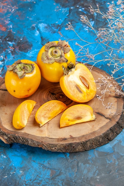 Vertical view of delicious whole and cut diospyros kaki with knife