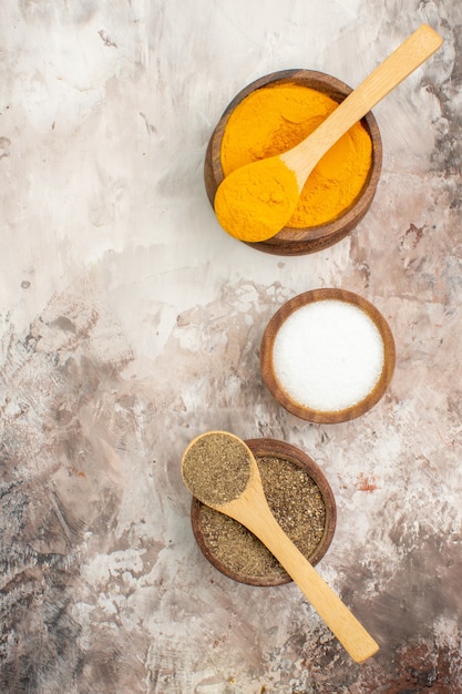 Vertical view of different spices with spoons