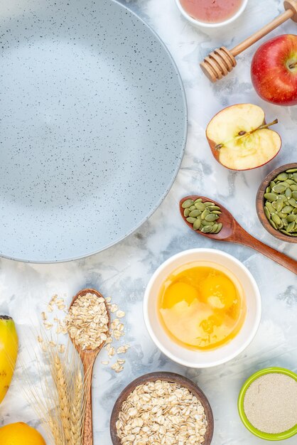 Vertical view of empty gray plate and ingredients for the healthy food set on ice background