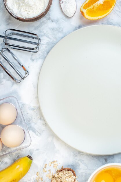 Vertical view of empty white plate and fresh healthy food set on ice background