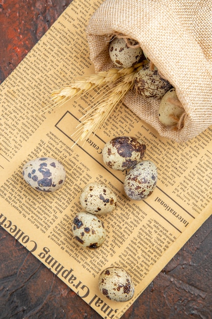 Vertical view of farm fresh eggs from fallen a white tissue bag and wooden pots on an old newspaper on a brown background