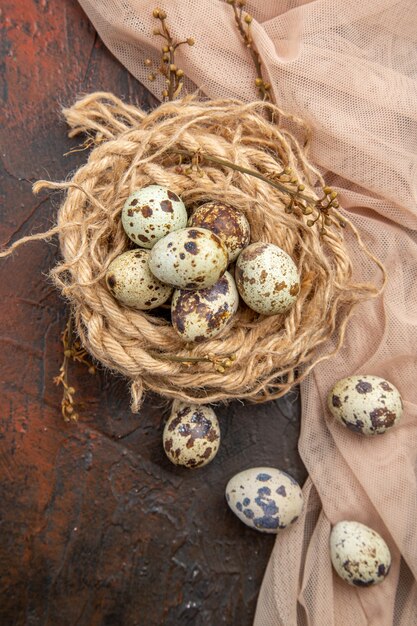 Vertical view of fresh eggs on a roll of rope and on towel on a brown table