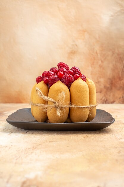 Vertical view of a gift cake for coffee and tea time with raspberries on a brown tray