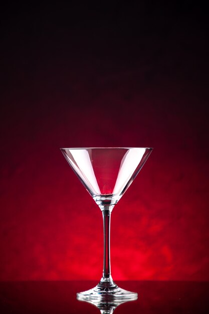 赤い背景の上に立っているワインのガラスゴブレットの垂直方向のビュー