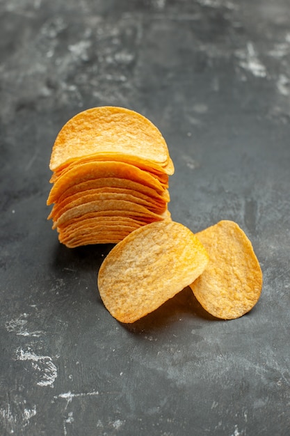 Vertical view of homemade stacked potato chips on gray background
